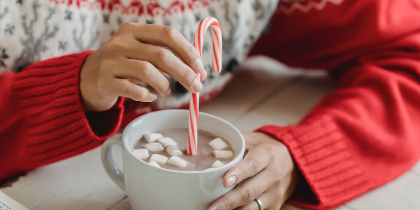 Woman stirring homemade hot cocoa with a candy cane